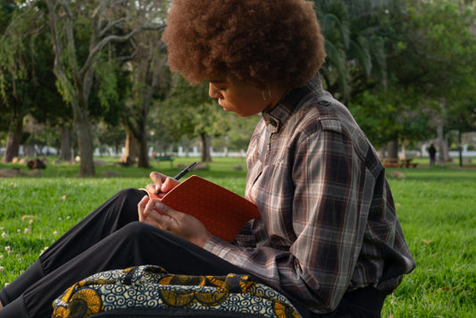 black woman journaling in park