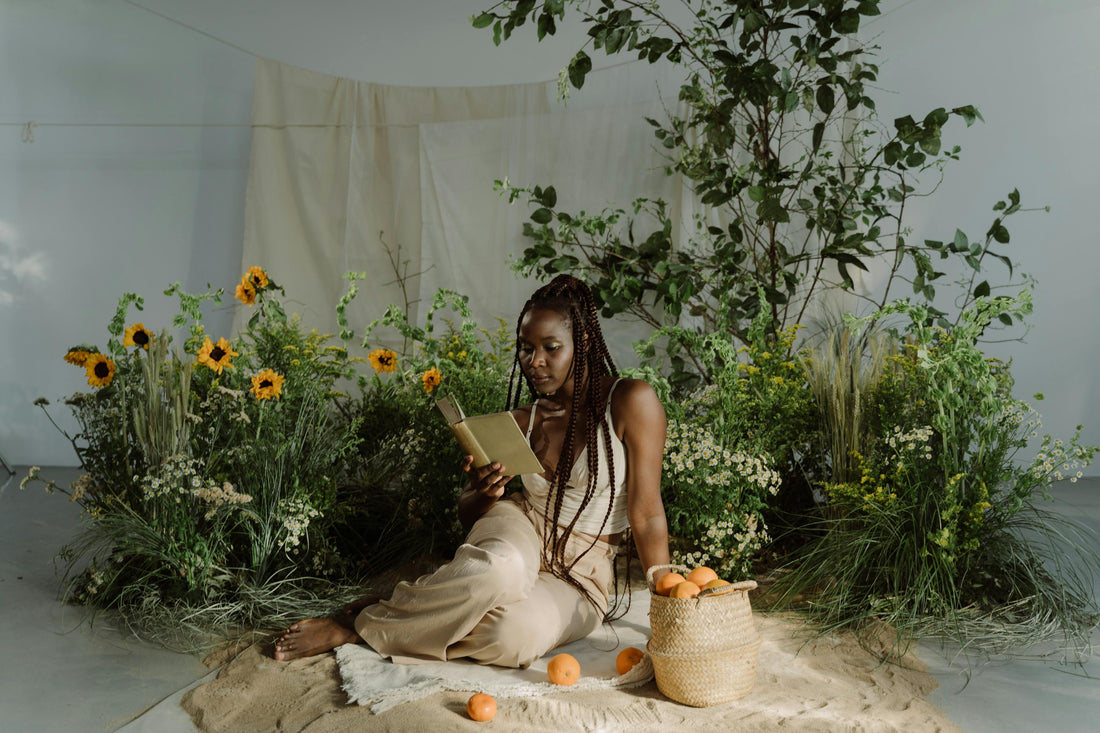 black woman reading surrounded by sunflowers